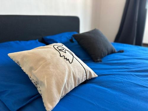 - un oreiller sur un lit avec des draps bleus dans l'établissement Toulon - Sea View and Coeur de Ville, à Toulon