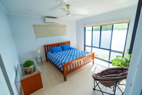a bedroom with a bed and a large window at Bungalow 58 Lake Bennett Darwin in Lake Bennett