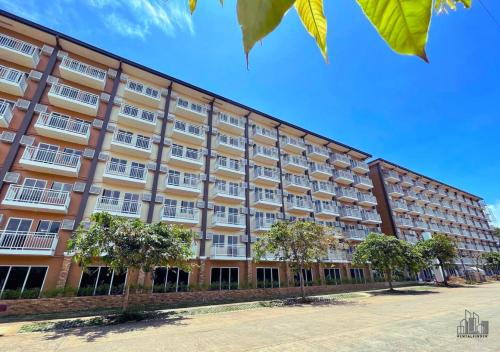 a large building with trees in front of it at Luxury Stay with Balcony, Free Gym & Pool in Bancao-Bancao - B2 6Luster in Puerto Princesa City