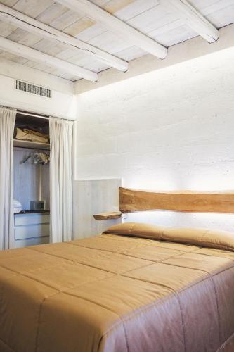 a bedroom with a large bed with a wooden headboard at Masseria Santa Teresa in Monopoli