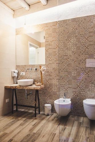 a bathroom with a sink and a toilet and a mirror at Masseria Santa Teresa in Monopoli