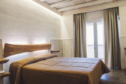 a bedroom with a bed and a large window at Masseria Santa Teresa in Monopoli