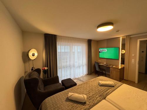 a hotel room with a bed and a flat screen tv at Boardinghouse HOME - adults only - in Konstanz