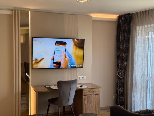 a living room with a television on a wall at Boardinghouse HOME - adults only - in Konstanz