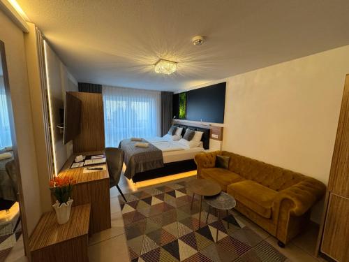 a hotel room with a bed and a couch at Boardinghouse HOME - adults only - in Konstanz