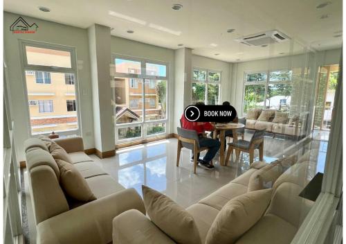 a man sitting at a piano in a living room at Luxury Stay with Balcony, Free Gym & Pool in Bancao-Bancao - B2 6Luster in Puerto Princesa City
