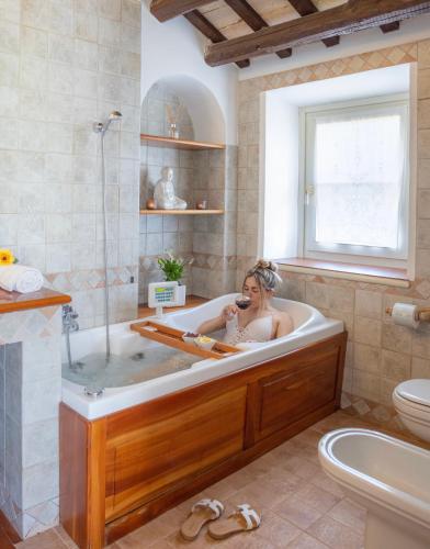 a woman in a bath tub in a bathroom at Villa LeMarche b&b in Rustico