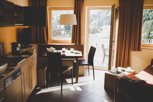 a kitchen with a table with chairs and a dining room at Arabella Retreat & Spa in Nauders