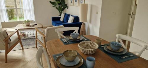 a living room with a table and chairs and a dining room at Lakestyle wellness met hottub en BBQ bij meer in Gelderland in Ewijk