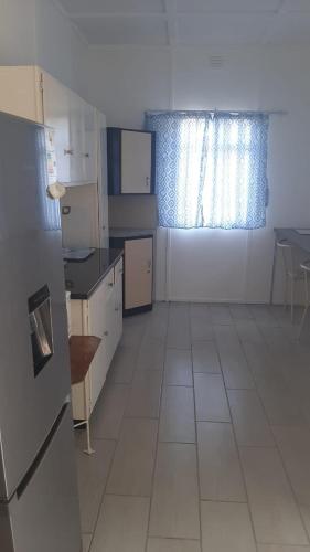 cocina con nevera y ventana. en Alhoa 3, en Gariepdam