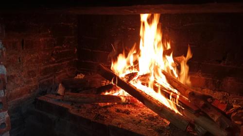 a fire burns in a brick fireplace at Higland Homestay Bac Ha in Bắc Hà