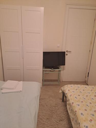 a bedroom with a bed and a tv in it at Sunset at Cape Sounio in Sounio