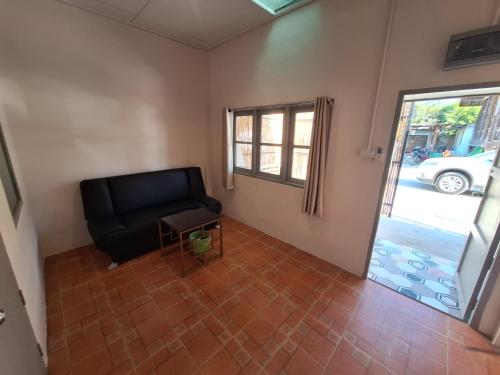 a living room with a black chair and a window at Slumberland at Pai in Pai