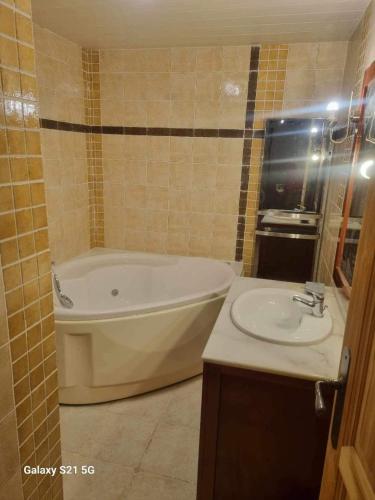 une salle de bain avec une baignoire et un lavabo dans l'établissement Chalet bois et pierre, à La Bresse