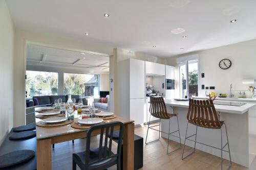 une cuisine et un salon avec une table et des chaises dans l'établissement Regalec - Jolie maison à St-Cast-le-Guildo, à Saint-Cast-le-Guildo