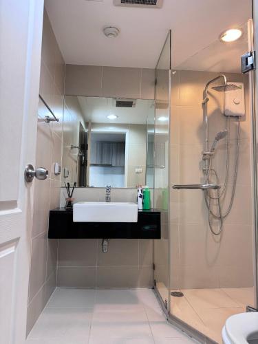 a bathroom with a sink and a shower at Rama9 Luxe Suites in Bangkok