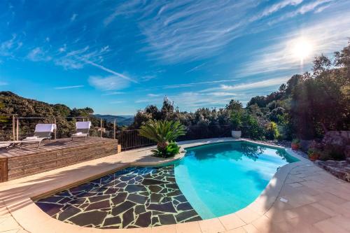 une piscine dans une cour avec un patio dans l'établissement Domaine Soleu - piscine et vue montagnes, à Montauroux