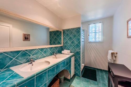 La salle de bains est pourvue de 2 lavabos et de carrelage vert. dans l'établissement Domaine Soleu - piscine et vue montagnes, à Montauroux