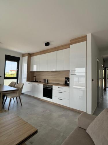 a kitchen with white cabinets and a table in a room at Theview 1 in Maslenica