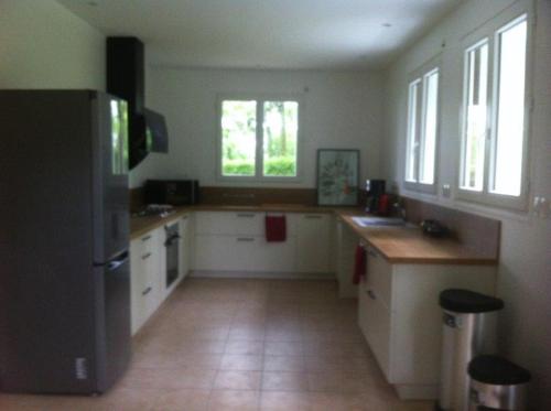  La cuisine est équipée de placards blancs et d'un réfrigérateur. dans l'établissement Gite de la Demi Lune, à Le Tremblay-le-Vicomte