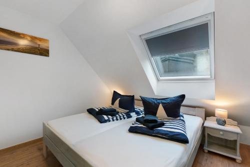 a bedroom with a bed with two pillows on it at Klaus Lafrenz Petersdorf N°3 in Fehmarn