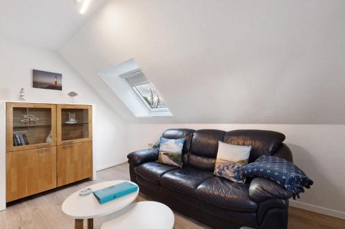 a living room with a leather couch and a table at Klaus Lafrenz Petersdorf N°2 in Fehmarn