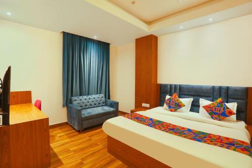 una habitación de hotel con una cama y una silla en Hotel Swarn Bhoomi, en Kānpur