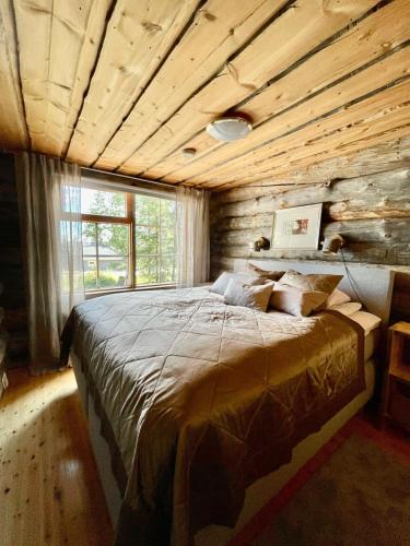 a bedroom with a large bed in a log cabin at Rukan Talvikota in Kuusamo