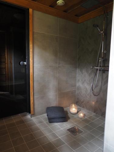 a bathroom with a shower with a blue towel on the floor at Rukan Talvikota in Kuusamo