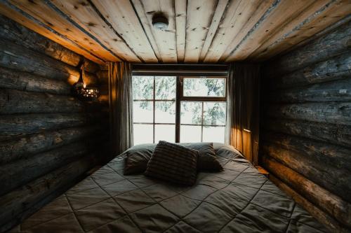 a bedroom with a bed in a room with a window at Rukan Talvikota in Kuusamo