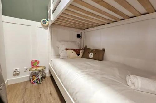 - un lit blanc dans une chambre dotée de parquet dans l'établissement Un jardin en ville - L Avenue des Voyageurs, à Boulogne-sur-Mer