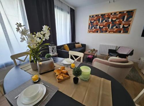 un salon avec une table et un salon avec une table dans l'établissement Un jardin en ville - L Avenue des Voyageurs, à Boulogne-sur-Mer