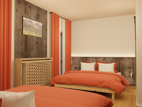 a bedroom with two beds with orange sheets at Hotel Dolomiti Des Alpes in Misurina
