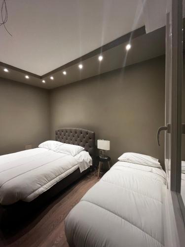 a bedroom with two beds and a headboard and lights at Stazione Tiburtina Roma in Rome
