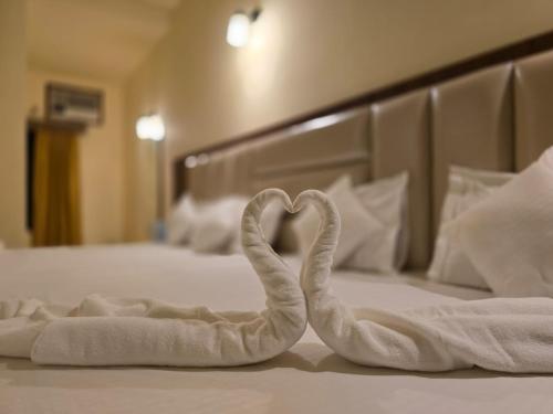two towels in the shape of a heart on a bed at Ricardo Beach Resort in Mandarmoni