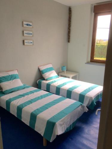 deux lits côte à côte dans une pièce dans l'établissement La maison de Berry, à Monistrol-sur-Loire