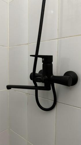 a black light fixture on a white tiled wall at Лучший хостел Алматы - Масанчи in Almaty