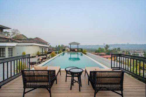 a balcony with chairs and a swimming pool at ELIVAAS 1 BHK with Rooftop Pool - Kamerios Skye in Nerul