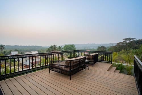 a deck with benches on top of a balcony at ELIVAAS 1 BHK with Rooftop Pool - Kamerios Skye in Nerul