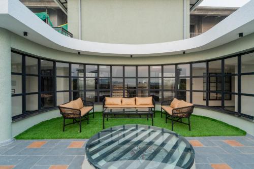 a room with chairs and a table in a building at ELIVAAS 1 BHK with Rooftop Pool - Kamerios Skye in Nerul