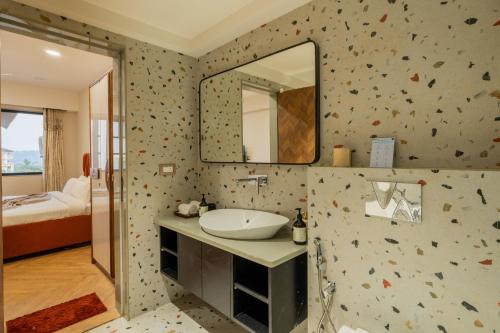 a bathroom with a sink and a mirror at ELIVAAS 1 BHK with Rooftop Pool - Kamerios Skye in Nerul