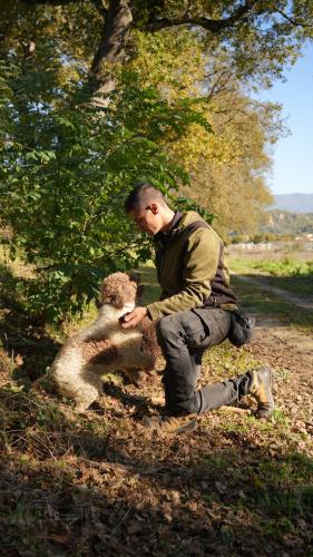 a man kneeling next to a monkey in a field at Viesca Toscana Suites & Villas in Reggello
