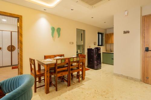 a kitchen and dining room with a table and chairs at ELIVAAS 1 BHK with Rooftop Pool - Kamerios Skye in Nerul