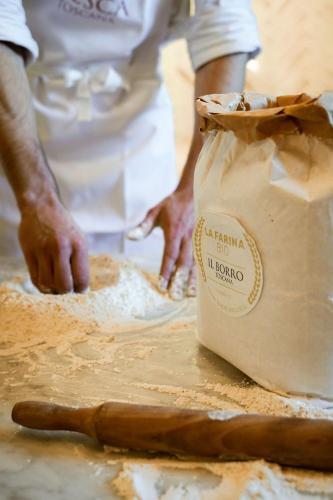 a person iseading dough on a table with a bag at Viesca Toscana Suites & Villas in Reggello