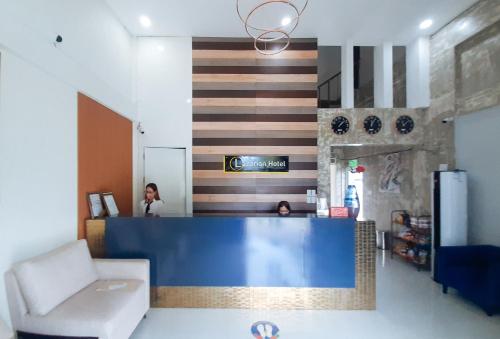 a lobby with a blue counter and a woman in a room at RedDoorz @ Lazarian Hotel and Resort Cagayan Valley in Macabbungao