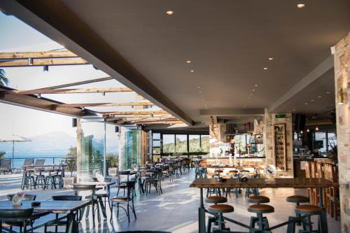 a restaurant with tables and chairs and a view of the ocean at Anthidon Nature Estate & Farm in Chalkida