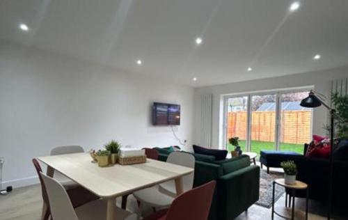 a living room with a table and a couch at London Mitcham Beautiful Three Bedroom House in Mitcham