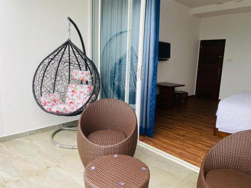 a room with two chairs and a hanging basket with flowers at Wooton Peak Resort in Kotagala
