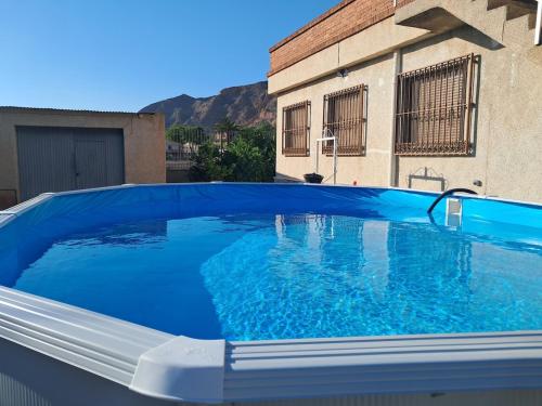 a large blue swimming pool in front of a building at La Casa de la Huerta de Redován in Redován