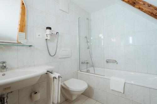 a bathroom with a toilet and a shower and a sink at Parkhotel Schwert in Weesen